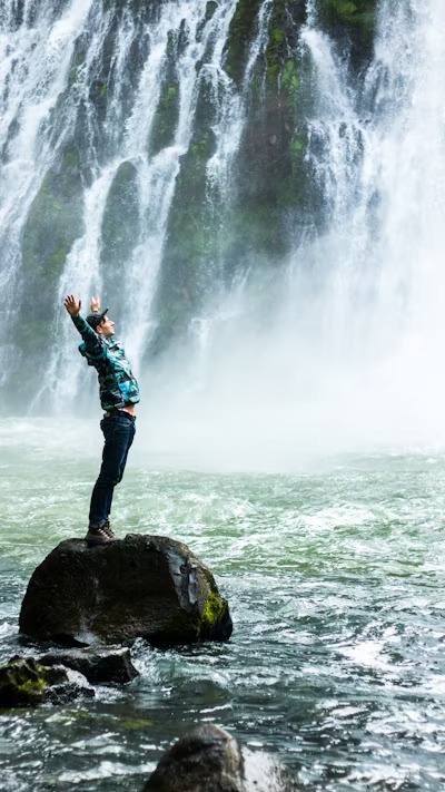 a happy nursing student enjoying nature by a waterfall