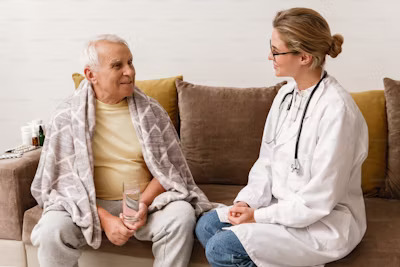a female geriatric nurse taking care of an elderly male patient