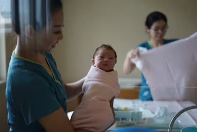 a nurse midwife holding a newborn baby