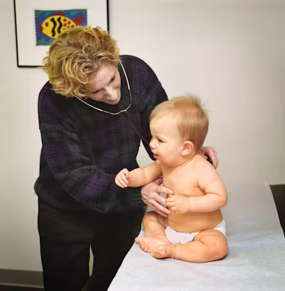 a pediatric nurse assessing a toddler using a stethoscope